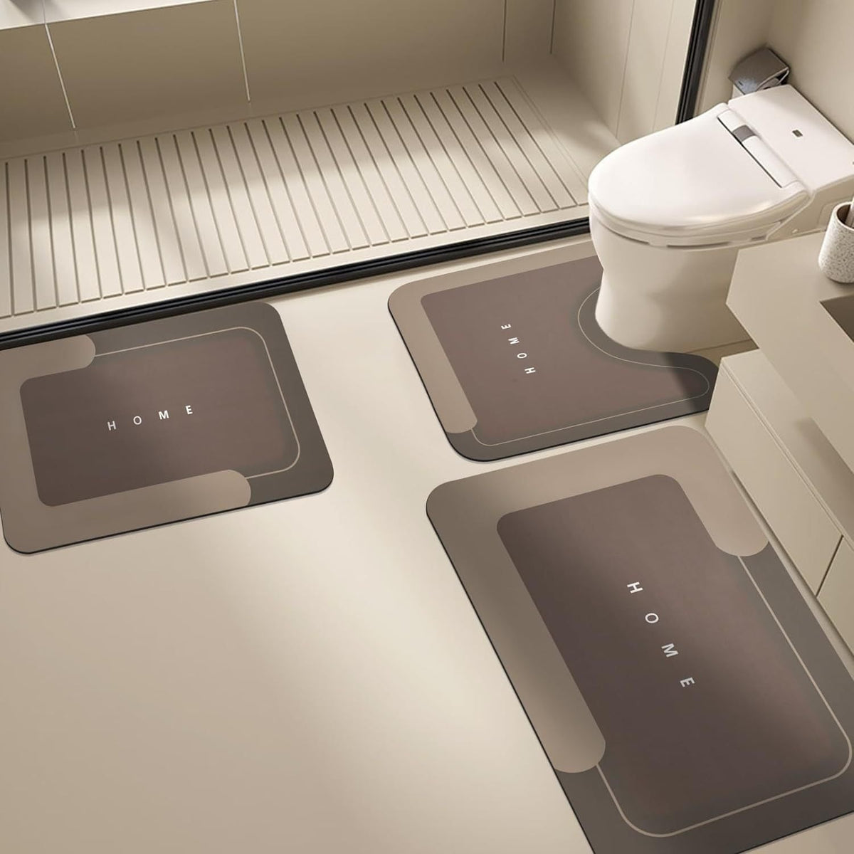 Brown Mattona 3-piece bath mat set with HOME lettering in a bathroom