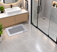 Gray HOME bath mat by Mattona, a single rectangular mat on a marble floor in front of a bathroom vanity
